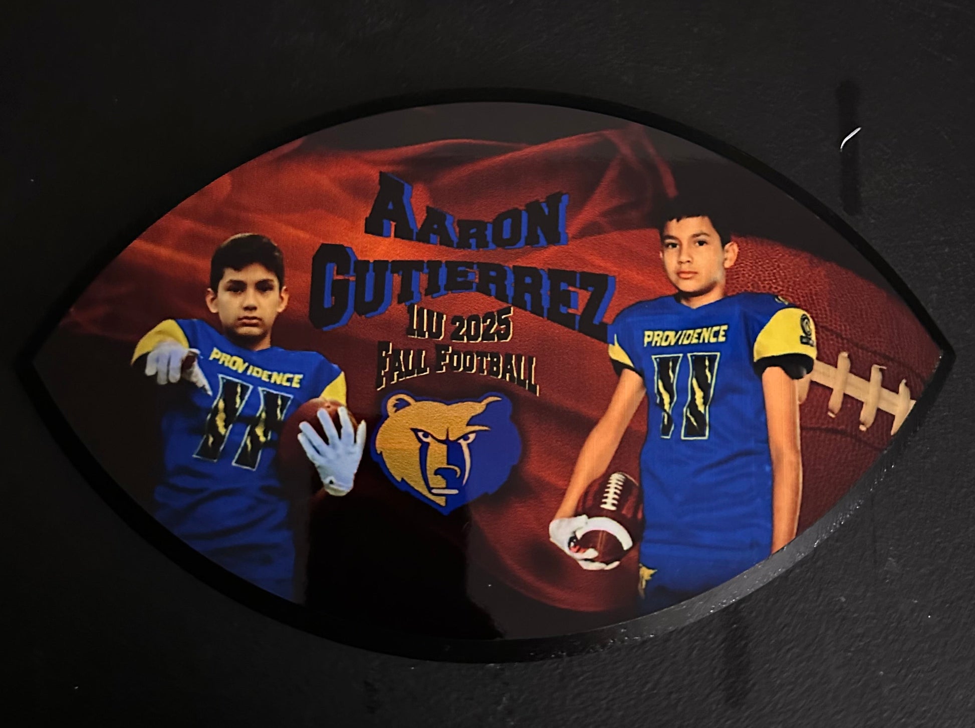 Decorative plaque with a football player design on a dark background